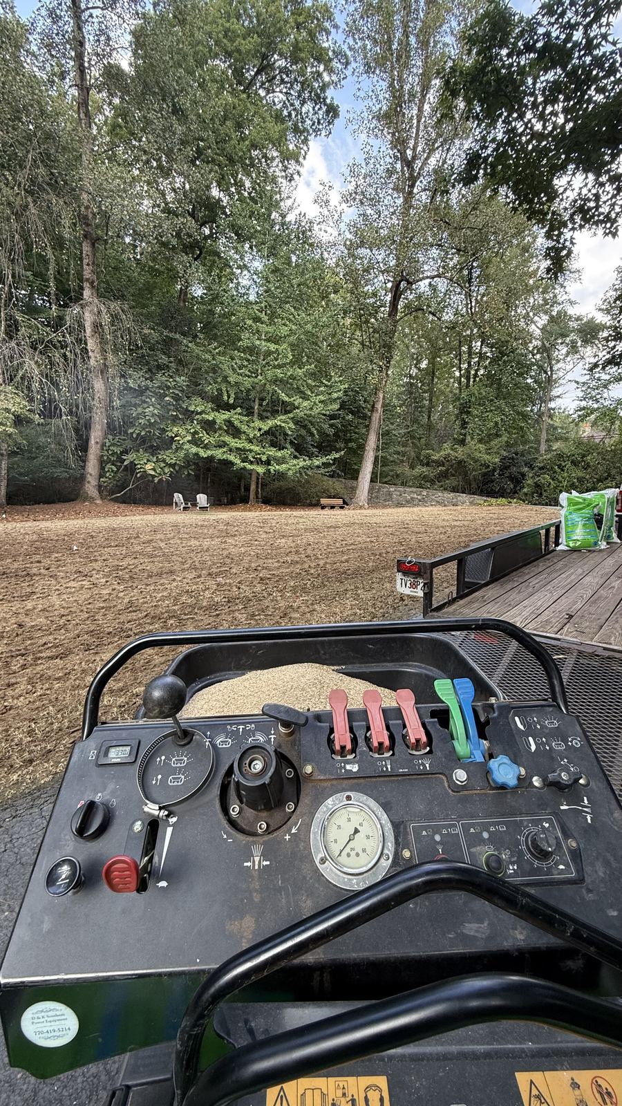 Core aerator controls with a large lawn ahead