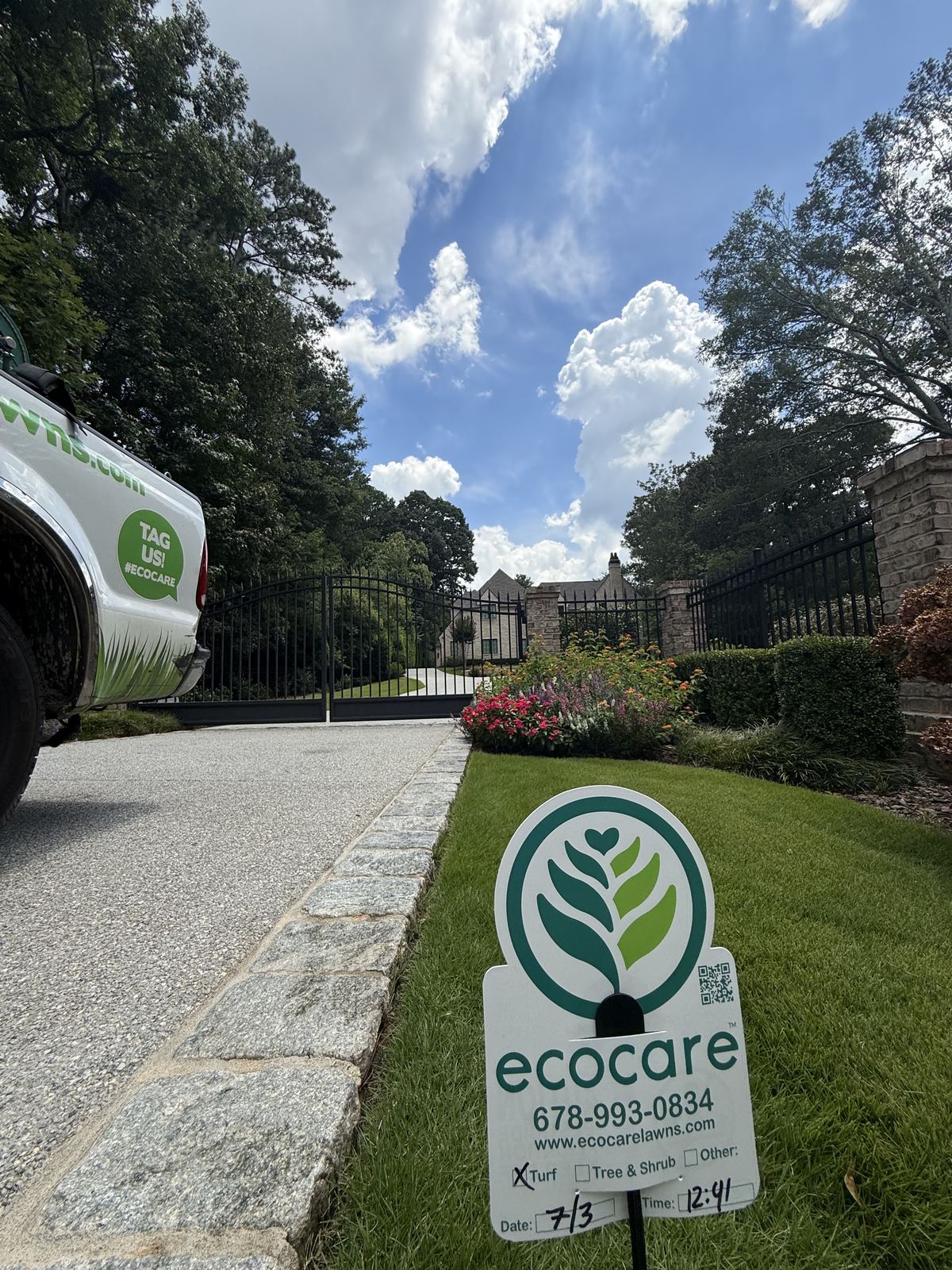 Ecocare yard sign and service truck at a property entrance